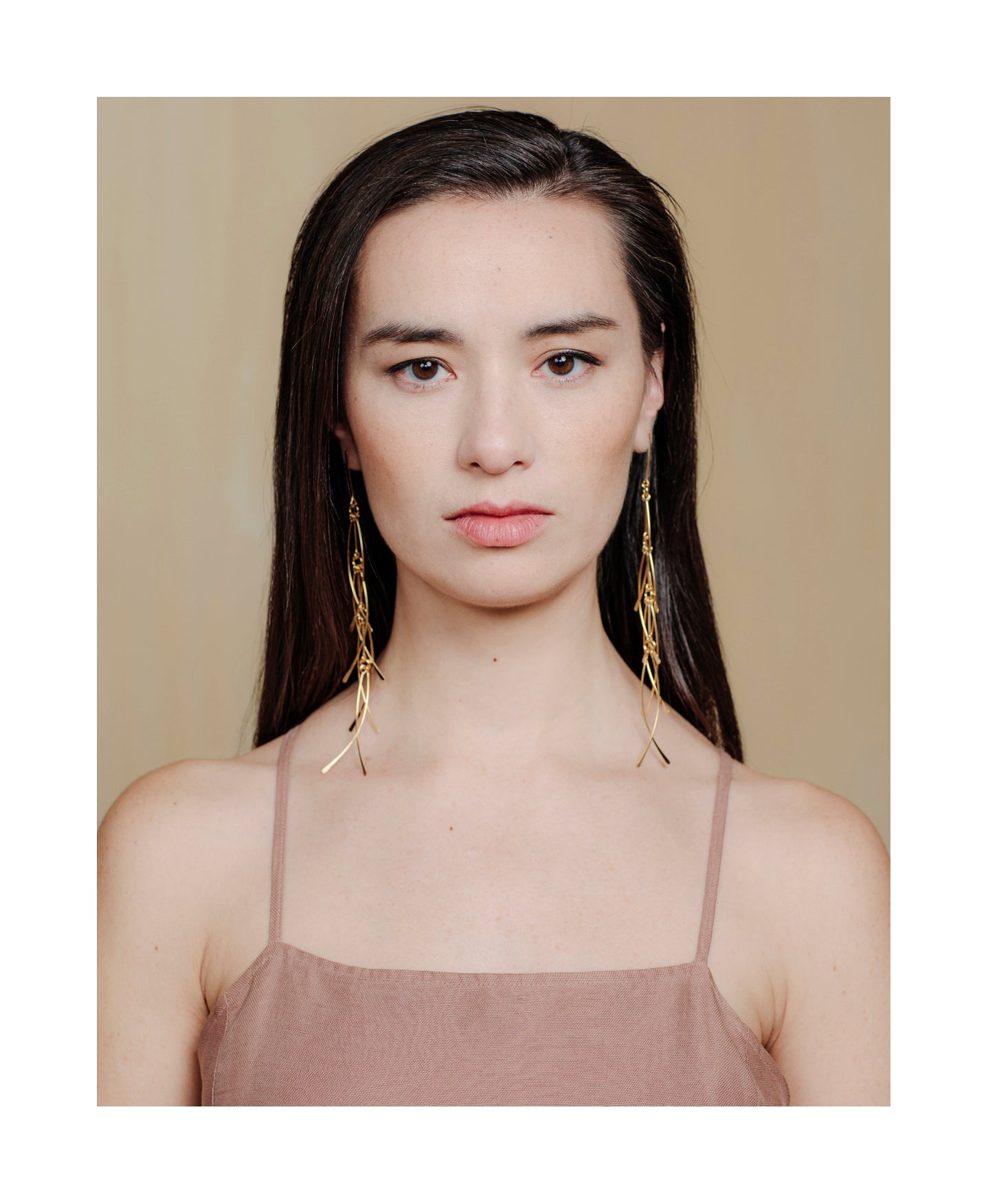 long lightweight gold earrings with feather detail