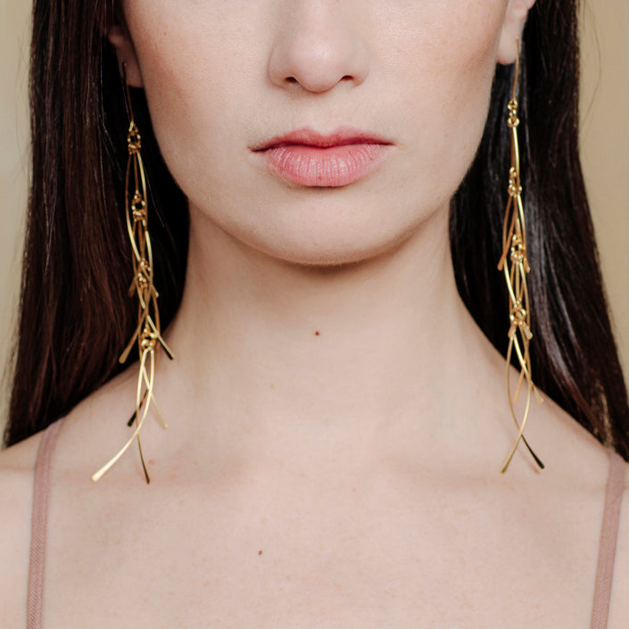 long lightweight gold earrings with feather detail