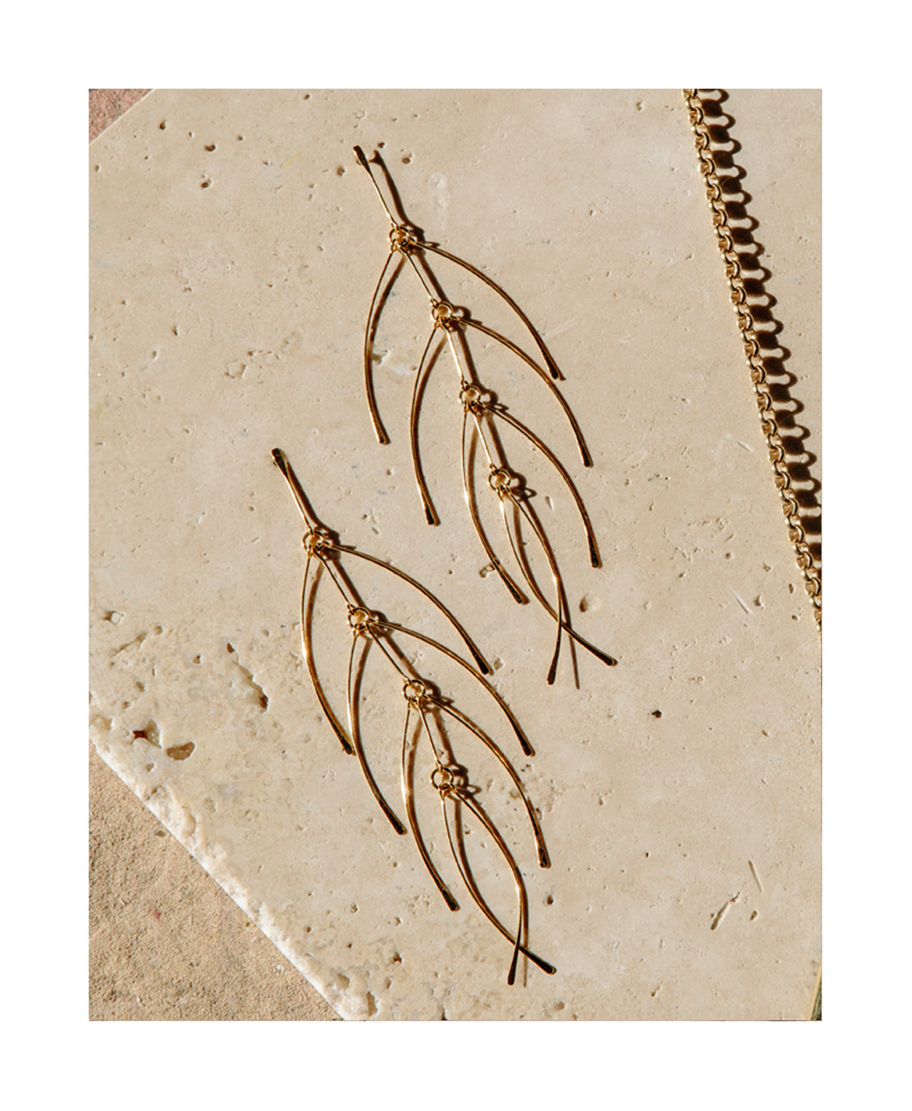 long lightweight gold earrings with feather detail